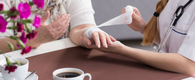 Nurse dressing a hand with bandage