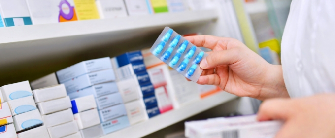 Pharmacist stocking antibiotic shelf