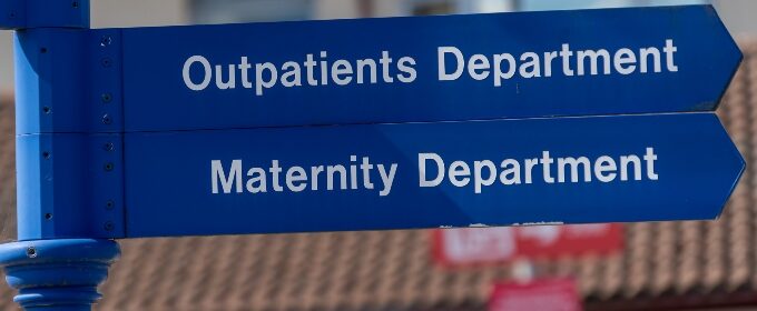 A hospital signpost, pointing toward the Outpatients Department, and the Maternity Department