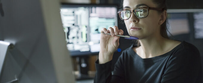 Article image - Woman monitors dark office