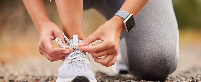 a sports woman tying her laces before training, running or a workout.