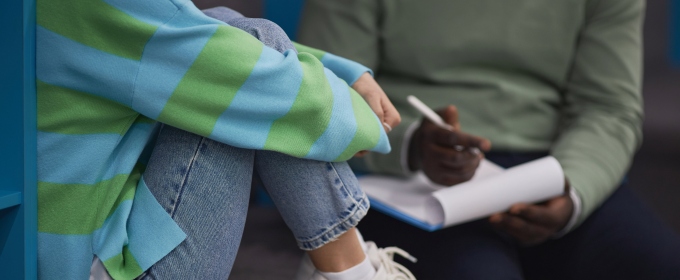 Closeup of stressed teenage girl talking to mental health therapist in session