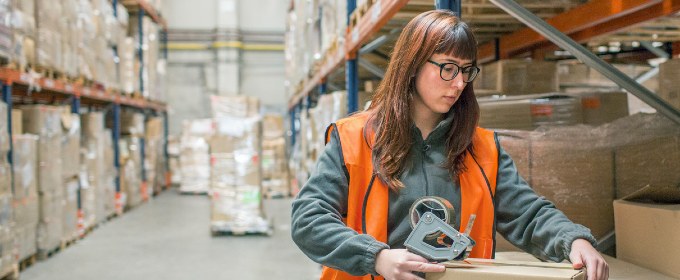 Woman working in a warehouse moving boxes