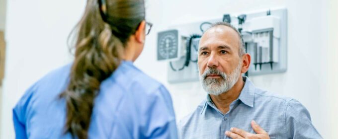 Image of older man having a health check with a medical professional.