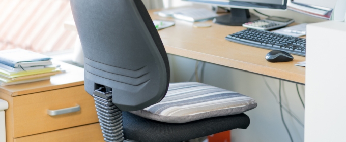 Close up on an empty desk chair in a home office.