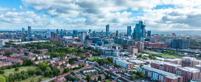 Image of the Manchester skyline on a day with sun and cloud