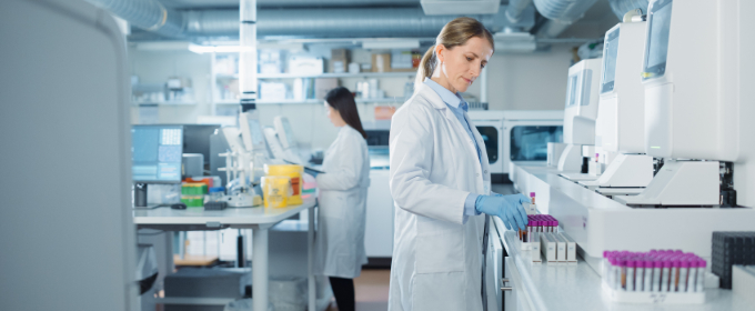 A diagnostics laboratory, with two workers in white coats operating laboratory equipment.