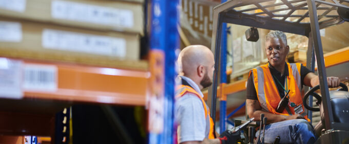 female fork lift driver with colleague